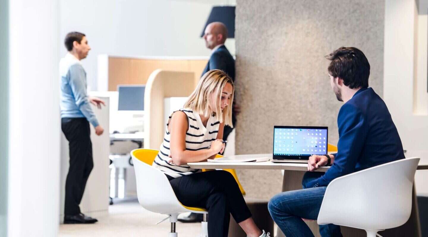 Des collaborateurs de Belcenter dans un bureau devant un PC avec les services Microsoft 365 en Belgique