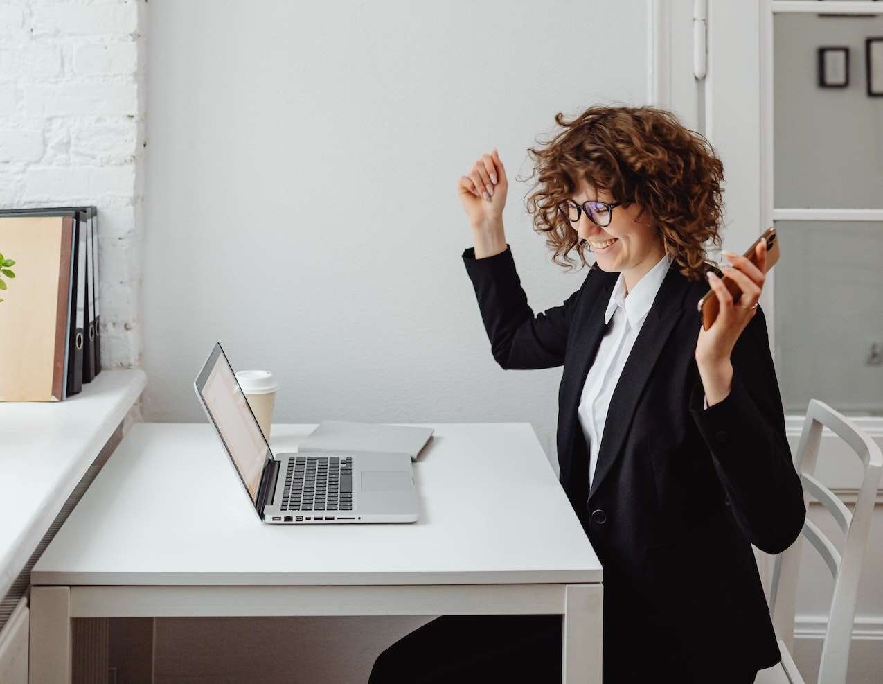 Une femme contente d'avoir choisir un bon opérateur télécom professionnel pour son entreprise devant son ordinateur portable : elle a choisi Belcenter